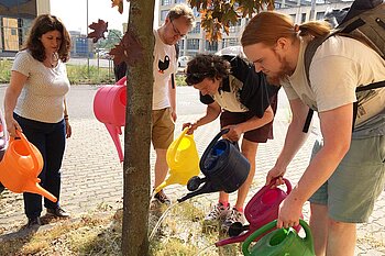Prof. Dr. Romy Morana und Studierende © HTW Berlin/Gisela Hüttinger Menschen gießen einen Baum