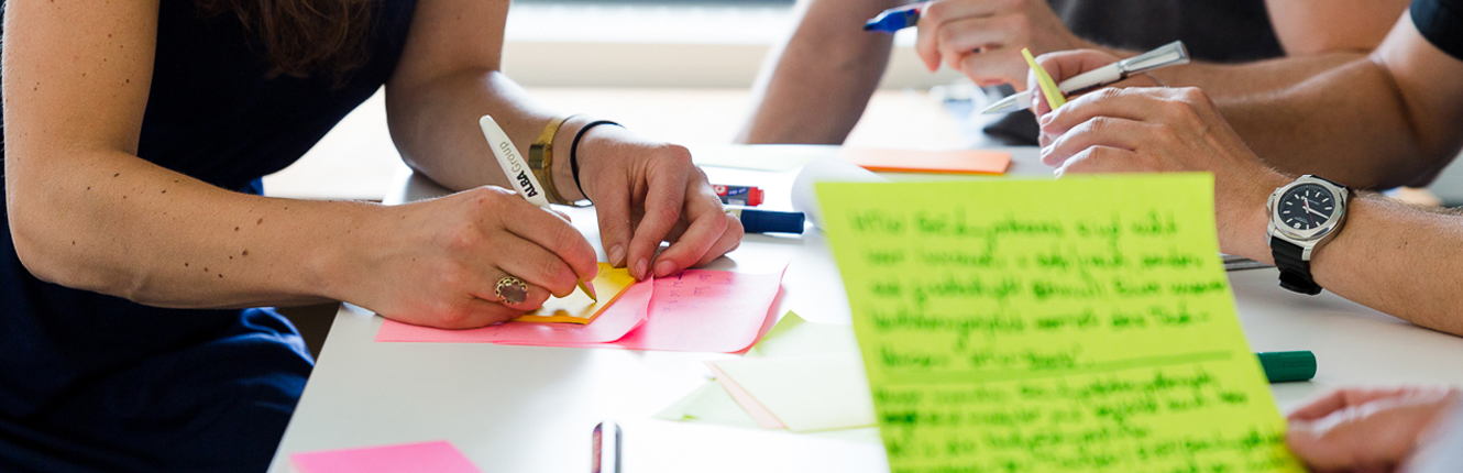 Foto: Personen kommunizieren mit Post-Its