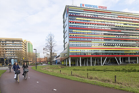Studierende auf dem Rad fahren am Campus der Universität Utrecht vorbei