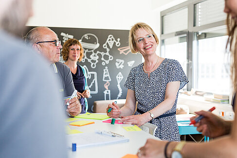 Mitarbeiter*innen in einer Teamsitzung