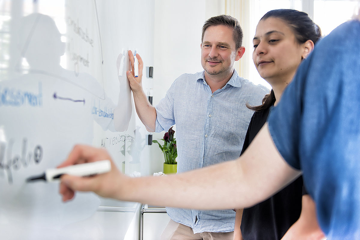 Eine Lehrperson und Expertinnen des LSC arbeiten gemeinsam am Whiteboard