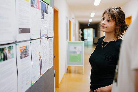 Studentin an einem Aushang mit Jobangeboten