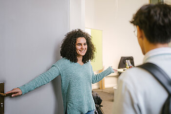 Studienberaterin bittet Studenten zu einem Beratungstermin herein