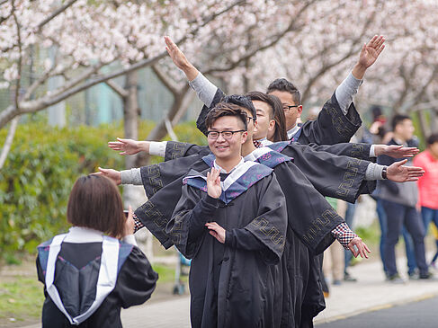 Studierende in Abschlusskleidung fotografieren sich beim Cherry-Festival der Tongji-Universität