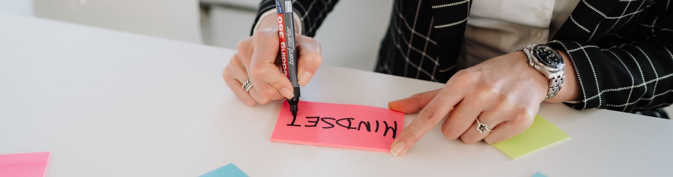 Jemand schreibt "Mindset" auf ein Post-it