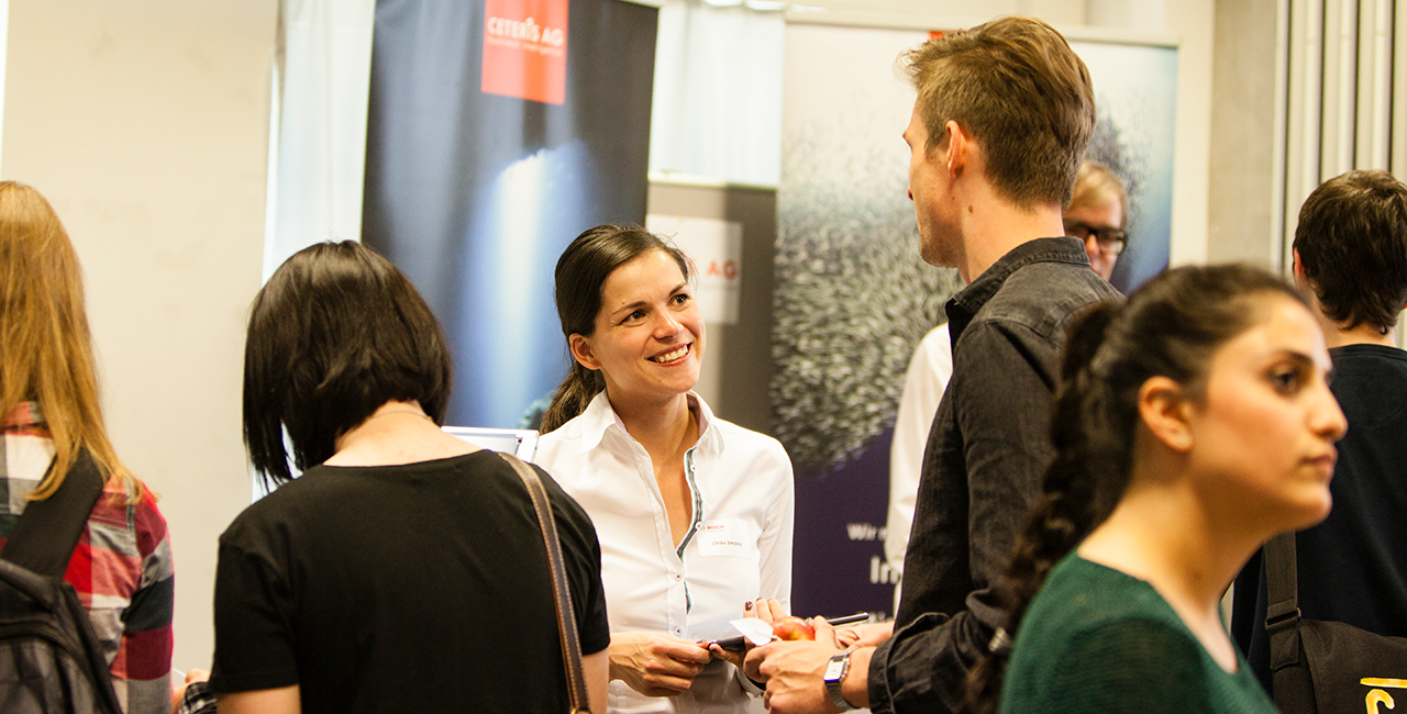 Two people in conversation at a career fair at HTW Berlin