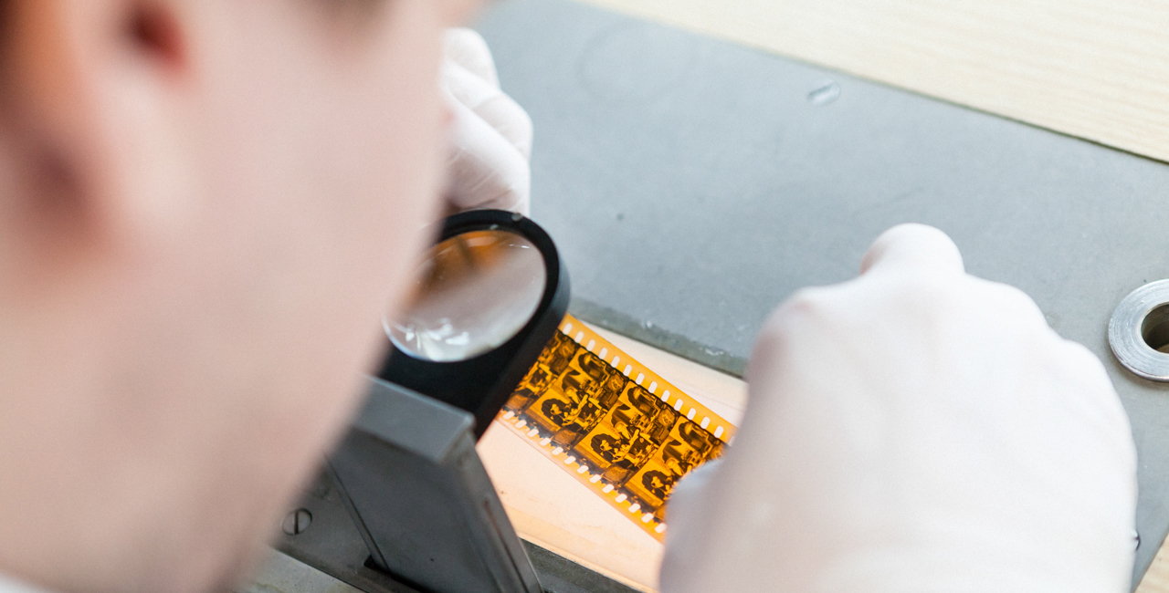 Student taking film strips under the magnifying glass