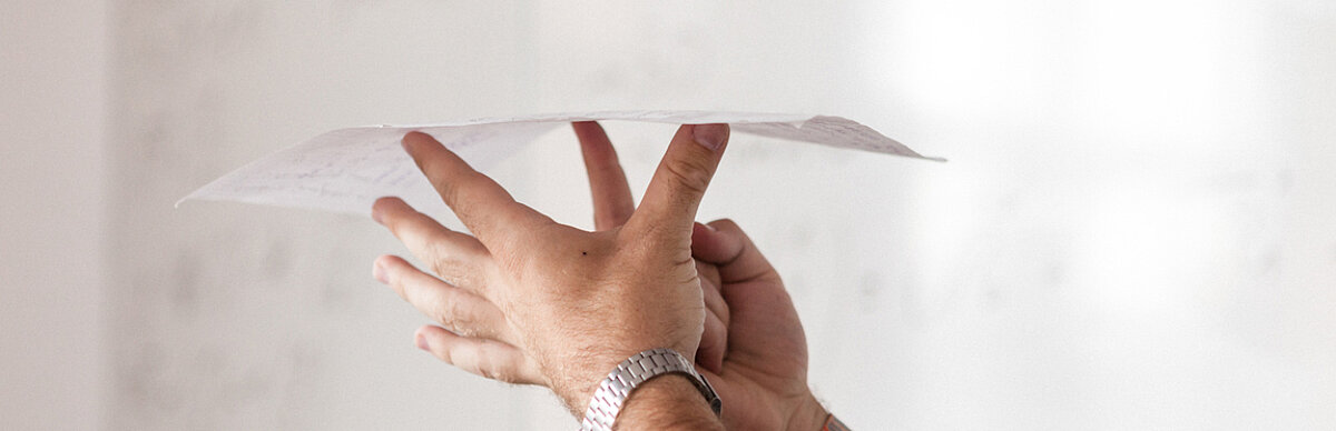 Two hands balancing a sheet of paper