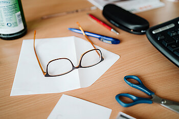 Arbeitstisch mit Brille und Büroutensilien