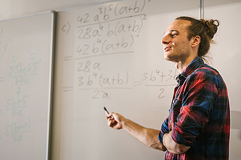 Tutor vor einem Whiteboard mit Mathe-Formeln