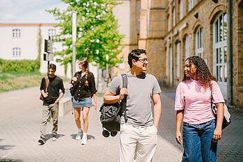 Mehrere Studierende gehen gemeinsam über den Campus.
