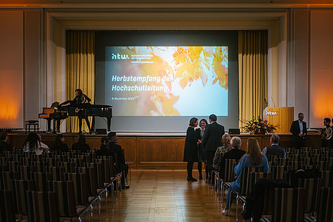 Blick ins Audimax und auf die Bühne, auf der eine Präsentation zum Herbstempfang zu sehen ist © HTW Berlin/Alexander Rentsch