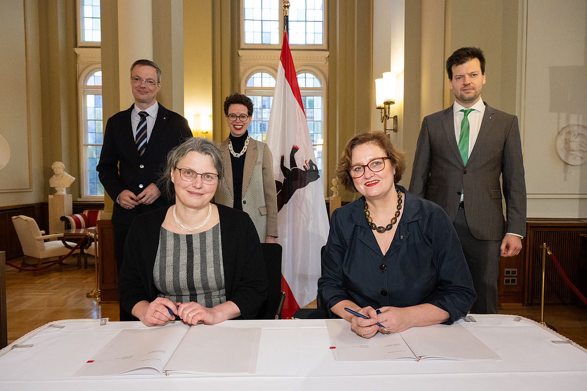 Prof. Dr. Annabella Rauscher-Scheibe und Dr. Ina Czyborra bei der Unterzeichnung des Hochschulvertrags. Im Hintergrund Prof. Dr. Tilo Wendler, Prof. Dr. Stefanie Molthagen-Schnöring und Dr. Henry Marx.