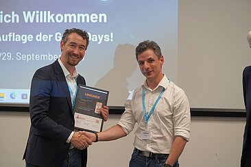 Martin Steinicke (links) nimmt die Urkunde von Giulio Crocco entgegen © TU Darmstadt/Ruben Gielisch