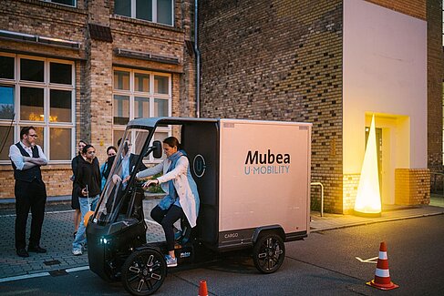 Eine Besucherin fährt einen Parcours mit einem Lasten-E-Bike bei der Langen Nacht der Wissenschaften 2024