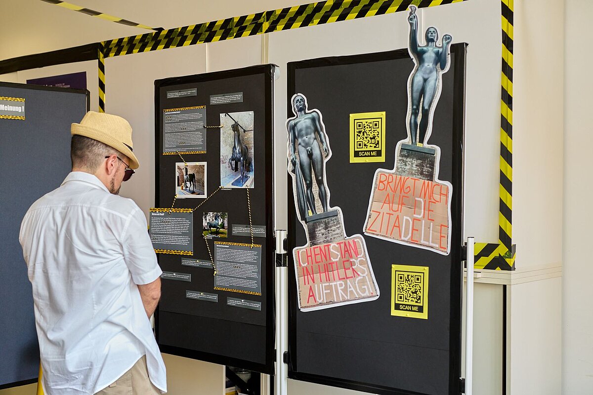 Ein Besucher vor einer Präsentationswand "Toxic Objects" bei der Werkschau 2024 © Andressa Clemente