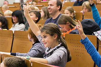 Mädchen bei der Kinderuni, das sich meldet