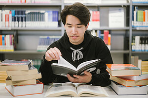 Student mit vielen Büchern © HTW Berlin/Alexander Rentsch