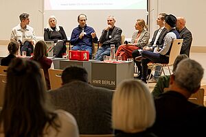 8 Personen auf einem Podium, im Hintergrund eine Präsentation zu BECOIL © Manfred H. Vogel