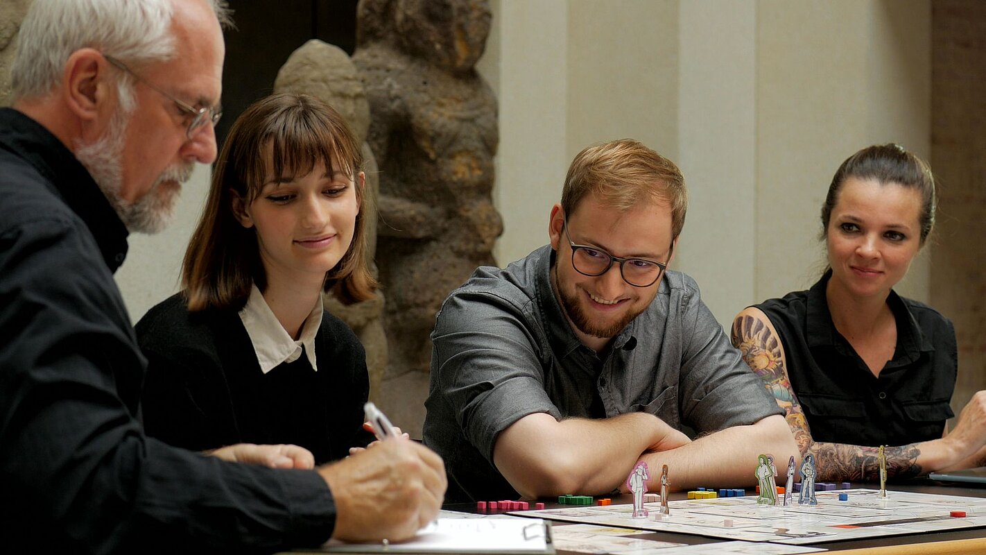 Eine Gruppe von vier Personen testet das Brettspiel © Berliner Antike-Kolleg/Karsten Prühl