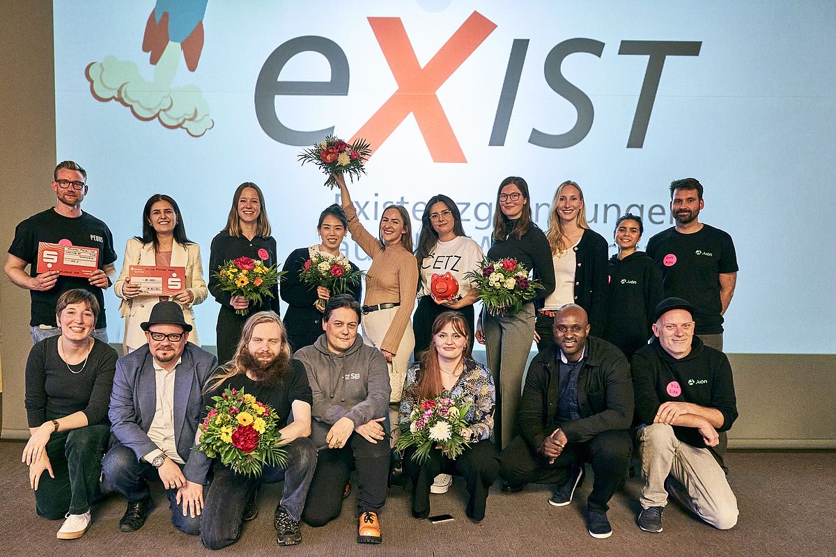 Die Gewinnerinnen und Gewinner auf der Bühne im Audimax der HTW Berlin. Im Hintergrund das Exist Logo.