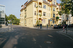 Eine Straßenkreuzung an einer Stadtvilla mit Fußgängern in Karlshorst