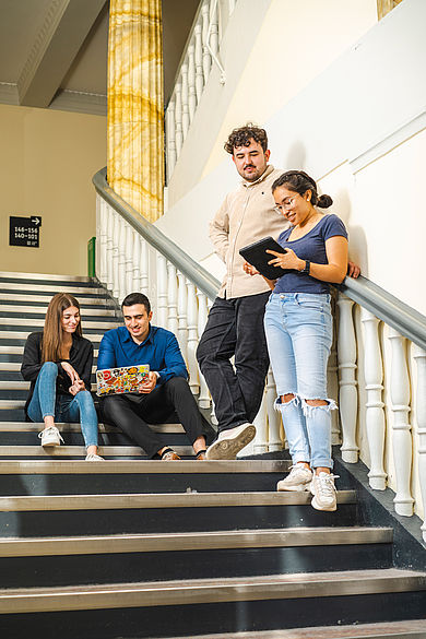 Studierende auf den Stufen in Gebäude A auf dem Campus Treskowallee