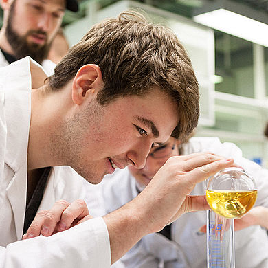 Student füllt Flüssigkeit in ein Reagenzglas