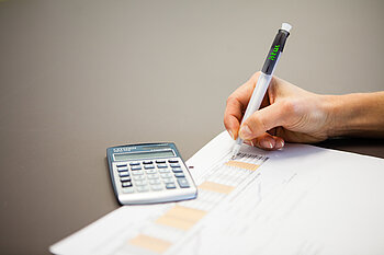 Taschenrechner auf einem Blatt mit statistischen Kennzahlen