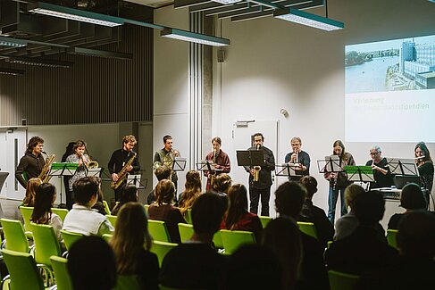 Zehn Musiker*innen mit Blasinstrumenten