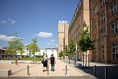 Zwei Studierende laufen über den Campus am Wilhelminenhof