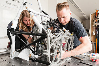 Zwei Studierende vom HTW-Motorsport bauen einen Boliden zusammen