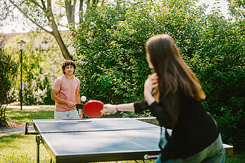 Zwei Studierende spielen Tischtennis.