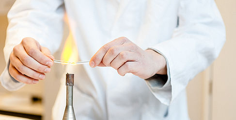 In the laboratory a tube is heated over a burner