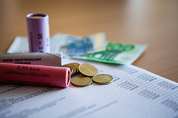 Geldscheine und Münzrollen