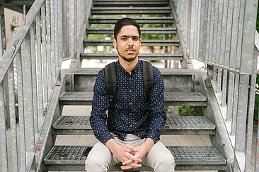Majed Dandal auf einer Treppe sitzend