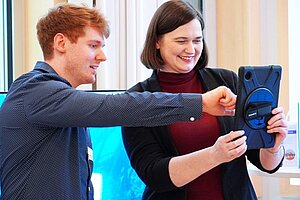 Zwei Personen schauen auf ein Tablet