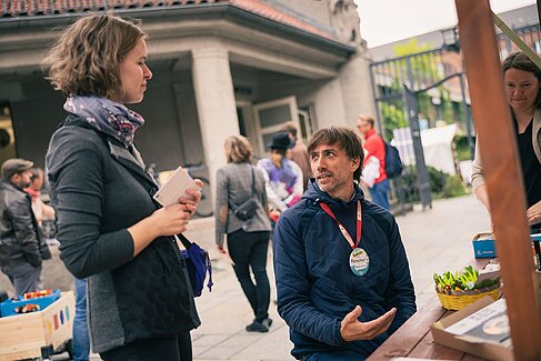 Zwei Menschen im Gespräch an einem Stand © Michael Rüger