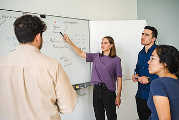 Studierende an einem Whiteboard