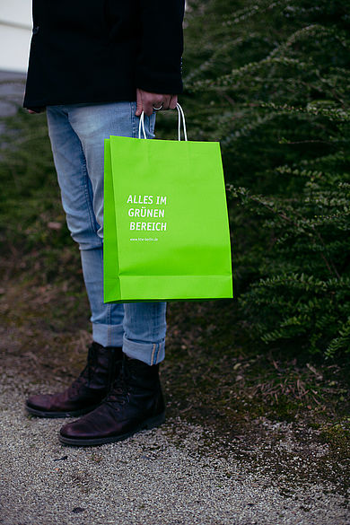 Mensch mit Papiertüte in der Hand