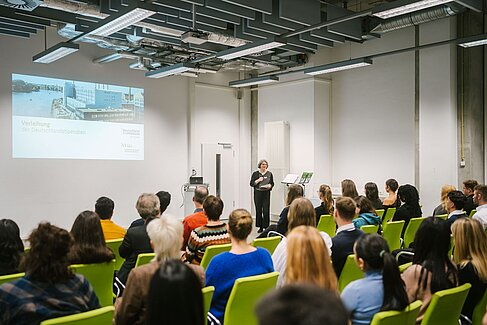 Präsidentin Prof. Dr. Rauscher-Scheibe spricht mit Mikro vor dem Publikum © HTW Berlin/Alexander Rentsch