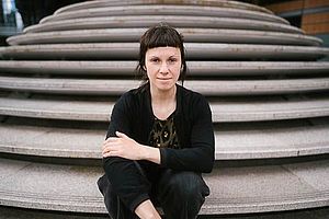 Helena Mihaljevic sitzt auf einer leeren Stein-Treppe