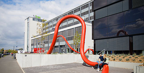 Mensagebäude mit roter Rohrschleife am Campus Wilhelminenhof