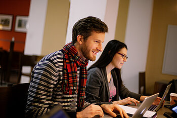Zwei Studierende am Laptop