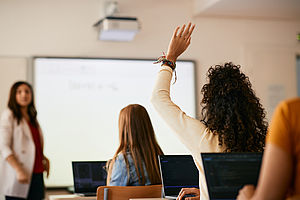 Professorin in einem Seminar, eine Studentin meldet sich © iStock.com - Drazen Zigic