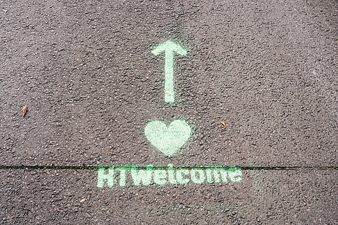 Auf Asphaltboden sind ein geradeaus-Pfeil, ein Herz und der Schriftzug HTWelcome zu sehen. © HTW Berlin