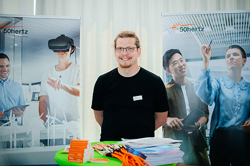 Mann einem Stand der Firma 50hertz © HTW Berlin Informatiktag/Alena Wilhelm